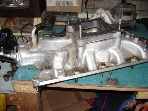 1981 Ford Mustang - This is an engine intake manifold, likely for a V8 engine, sitting on a workbench.
