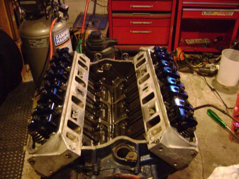 1981 Ford Mustang - V8 engine block with valve covers removed, showing internal components. Garage setting.
