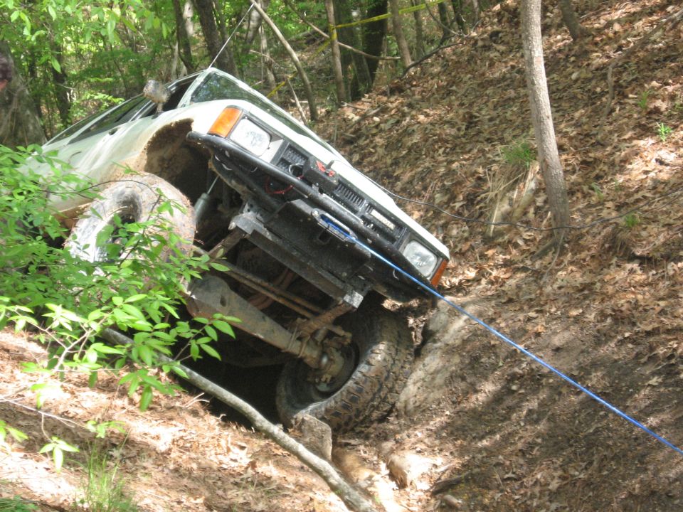 1984 Ford Bronco II winching itself up a steep, wooded incline