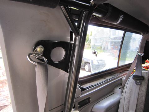 1996 Ford Bronco - Interior view showing a roll cage and seatbelt, with another vehicle visible through the window.