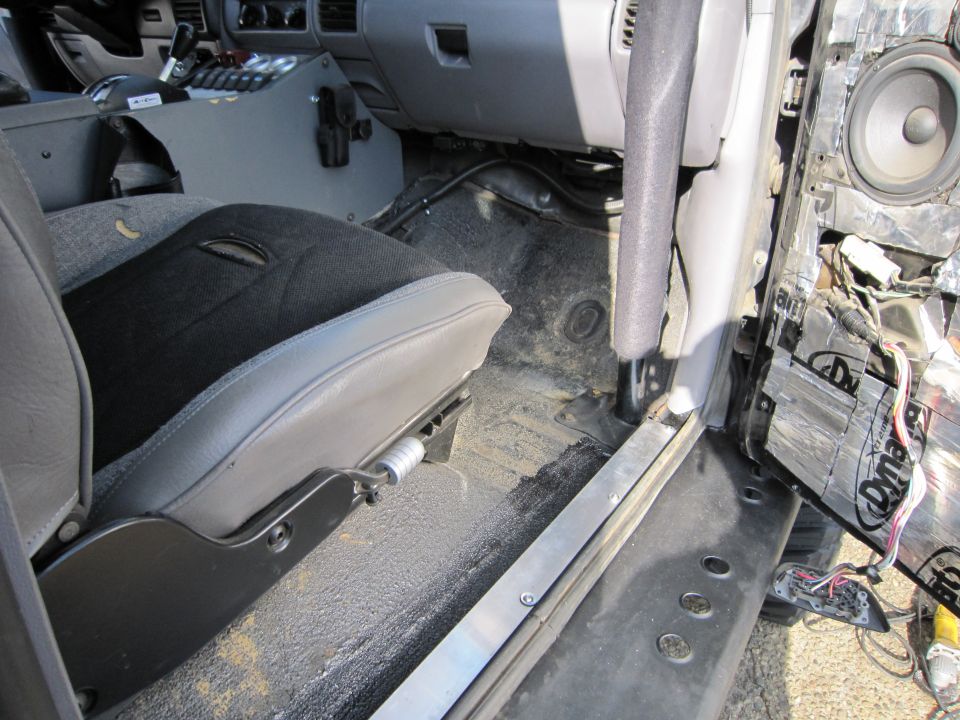 1996 Ford Bronco interior showing driver's seat, dashboard, and removed door panel with speaker and sound deadening