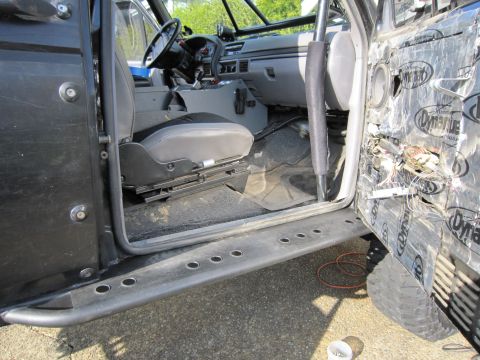 1996 Ford Bronco - Interior view of a modified Ford Bronco, showing the dashboard, seats, and a disassembled door panel.