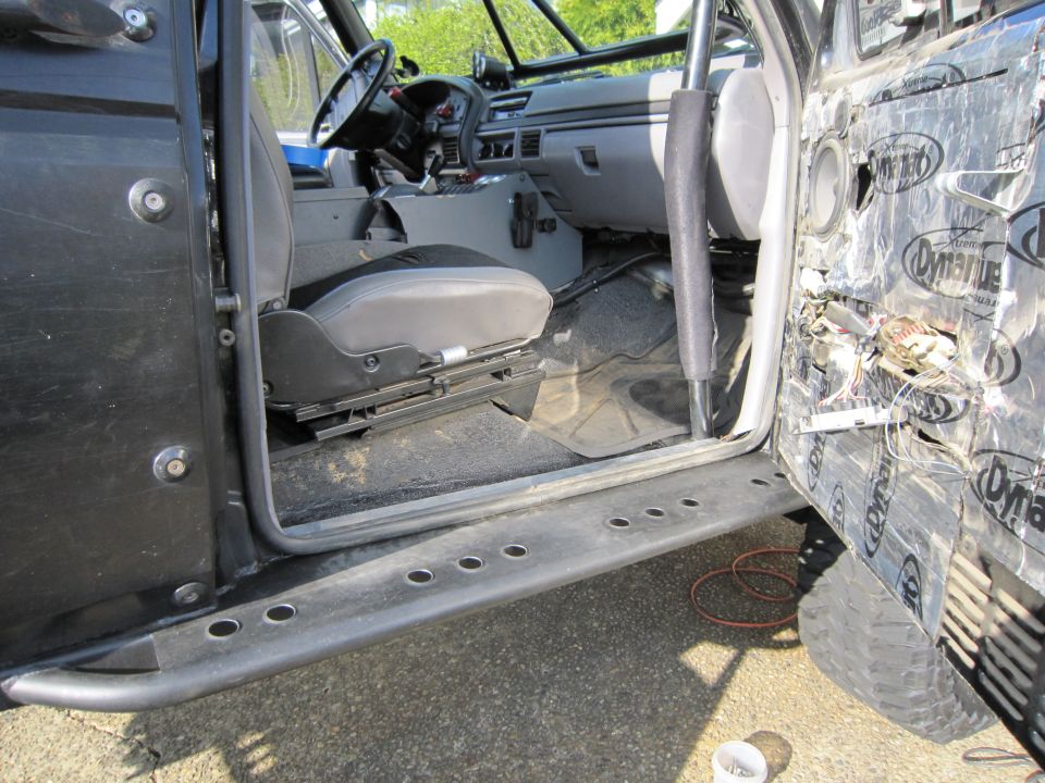 Black Ford Bronco interior with exposed door panel wiring and sound deadening