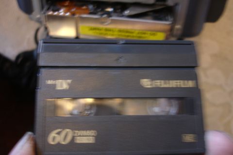 1993 Ford Taurus - A Fujifilm mini-DV tape is held in hand, showing the tape window and recording time.