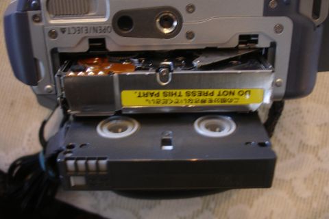 1993 Ford Taurus - A close-up view of a camcorder's tape loading mechanism, a prominent warning label.