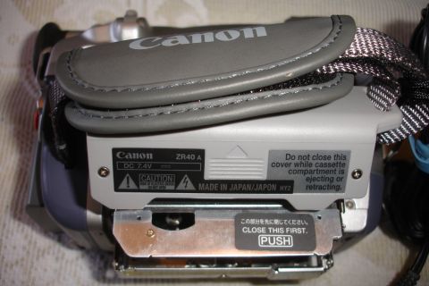 1993 Ford Taurus - Close-up of a Canon ZR40 A camcorder, showing the battery compartment and operational instructions.
