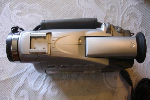 1993 Ford Taurus - Side view of a silver camcorder, showing operational buttons and a pull-tab on the viewfinder.