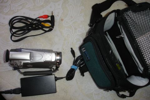 1993 Ford Taurus - A silver camcorder is laid out with its accessories, including various cables, a power adapter, and a carrying bag.