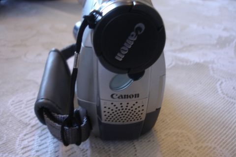 1993 Ford Taurus - A Canon video camera is shown with its lens cap attached, resting on a textured surface.