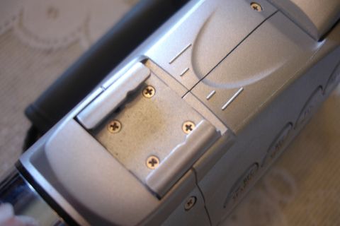 1993 Ford Taurus - A close-up view of a silver camcorder's top section, showing mounting hardware and buttons.