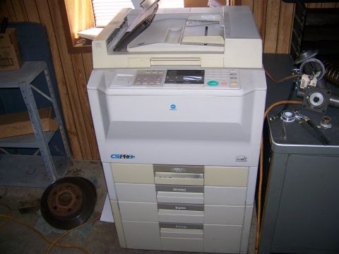 2001 Dodge 1500 - A copier sits on the floor next to a metal shelf and a brake rotor.