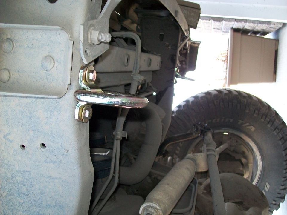 Underbody truck suspension with zinc bracket bolted to frame, BFG All-Terrain tire behind.