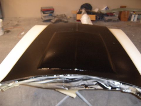 1973 Ford Ranchero - A car hood is prepared for painting in a workshop setting.
