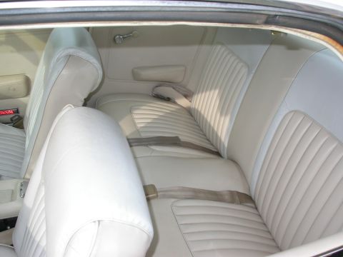 1968 Mercury Cougar - Interior view of a car white pleated seats and seatbelts.