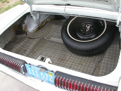 1968 Mercury Cougar - Trunk interior of a 1968 Mercury Cougar, complete with spare tire and plaid matting.