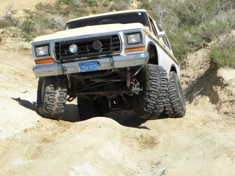 1995 Ford Bronco - This heavily modified pickup truck navigates a challenging off-road trail.