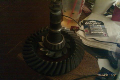 2000 Mercury Grand Marquis - A close-up of a differential gear and pinion assembly, with batteries and a drink nearby.