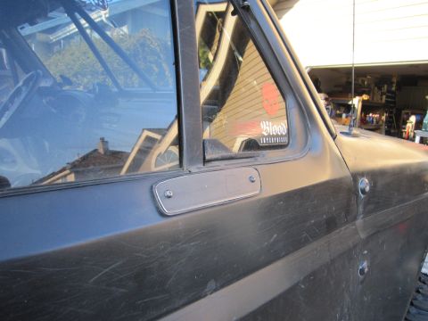 1996 Ford Bronco - A close-up shot of a dark SUV's side door and window, a 'Blood Enterprise' sticker.
