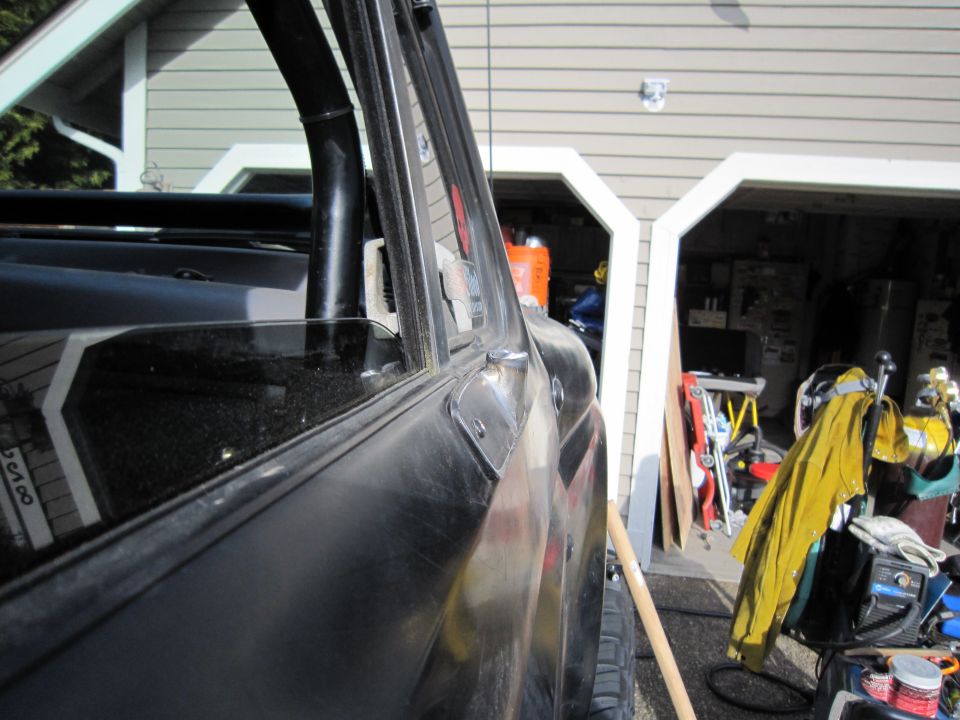 Side view of a black SUV, showing the door and window frame. Garage in background