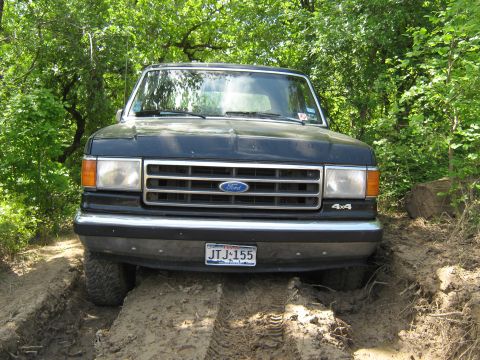 Black Ford Bronco 4x4 on dirt track, front view. License plate JTJ-155