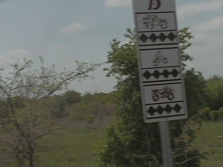Sign with icons for motorcycles, ATVs, and possibly a golf cart