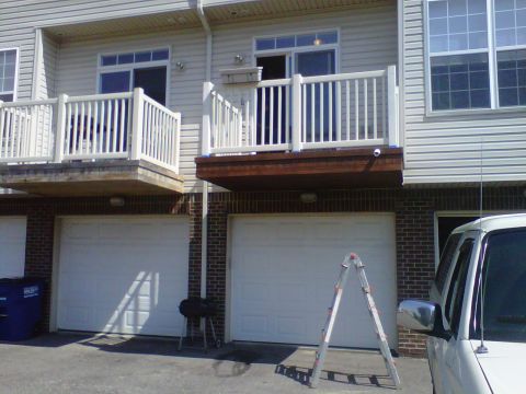 1995 Ford Bronco - A white SUV is parked in front of a townhouse with two garage doors.