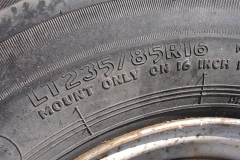 1993 Ford Taurus - Close-up of a tire sidewall displaying its size and mounting instructions.