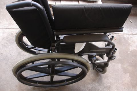 1993 Ford Taurus - A wheelchair is shown from the side, with black upholstery and large wheels.