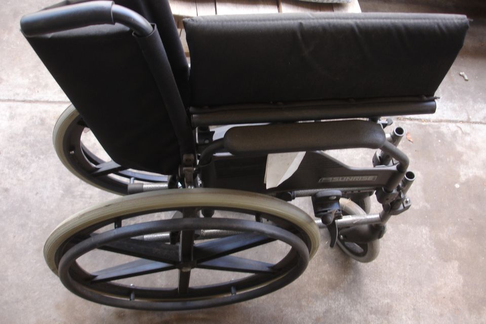 Wheelchair side view, black seat and large spoked wheels