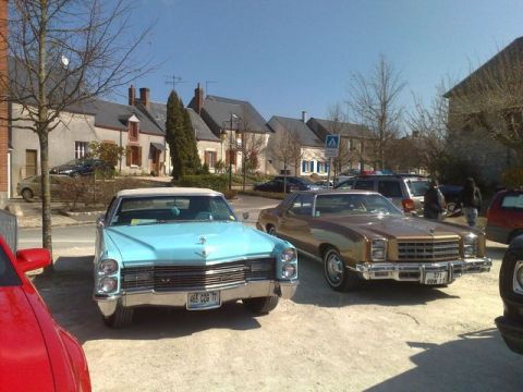 1991 Ford Crown Victoria - A brown coupe with a 1977 license plate is parked next to a light blue convertible.