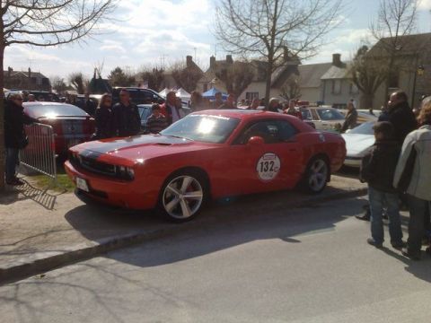 1991 Ford Crown Victoria - A red Dodge Challenger is parked on a street with spectators around it.