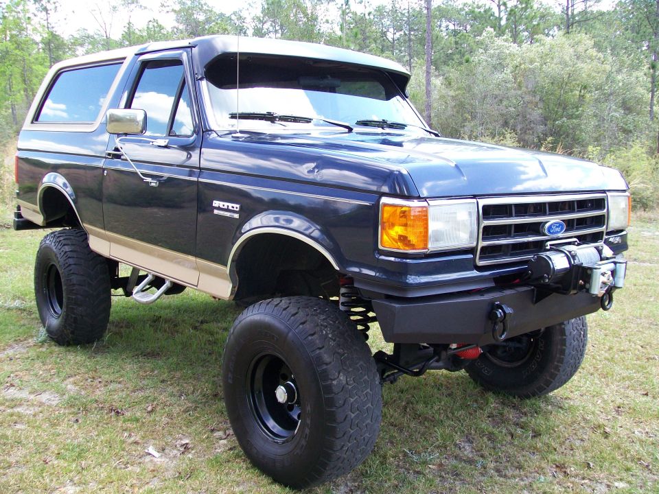 1990 Ford Bronco lifted with large tires and a front winch