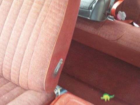 1988 Ford Bronco - Close-up view of the red striped interior seats and seatbelt buckle.