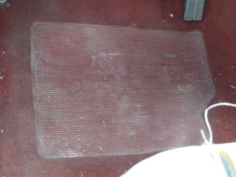 1988 Ford Bronco - Clear plastic floor mat covers the red carpeted floor of a vehicle.