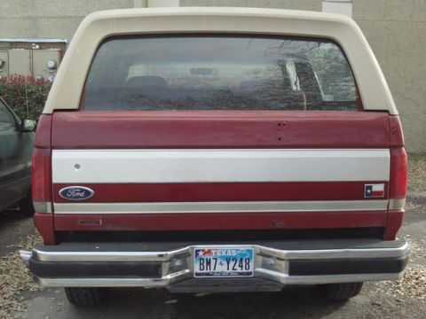 1988 Ford Bronco - Rear view of a red and tan Ford Bronco with a Texas license plate.
