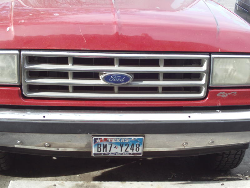 Red 1988 Ford Bronco front grille with Ford logo and Texas license plate