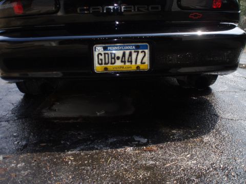 2002 Chevrolet Camaro - The rear of a black 2002 Chevrolet Camaro is visible, dual exhaust pipes and a Pennsylvania license plate.
