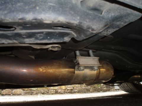 2002 Chevrolet Camaro - Close-up view of an exhaust pipe and its clamp, seen from below.