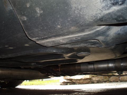 2002 Chevrolet Camaro - Close-up of a vehicle's underbody, focusing on the exhaust system and protective panels.