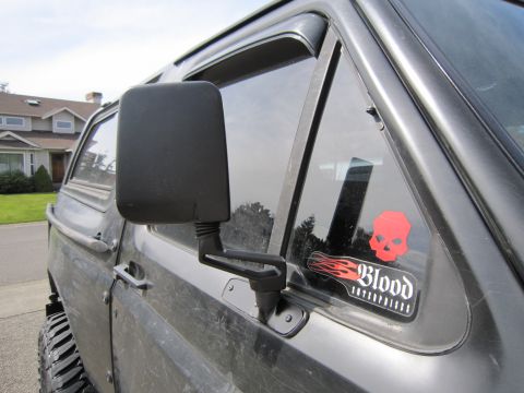 1996 Ford Bronco - Close-up view of a side mirror and a "Blood" sticker with a skull on a vehicle's window.