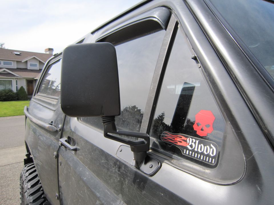 Side mirror and red skull sticker with "Blood" text on a dark vehicle