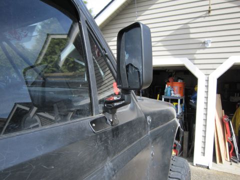 1996 Ford Bronco - Close-up of an aftermarket side mirror attached to a vehicle door.