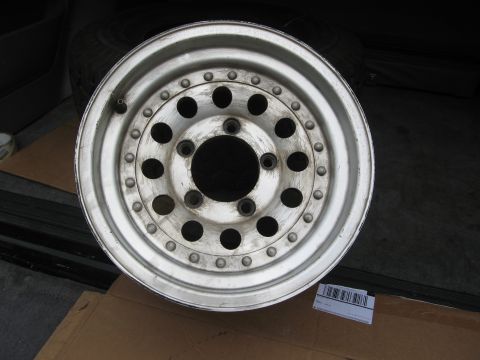 1986 Ford Bronco - A single aluminum wheel is shown, resting on cardboard with a barcode sticker nearby.