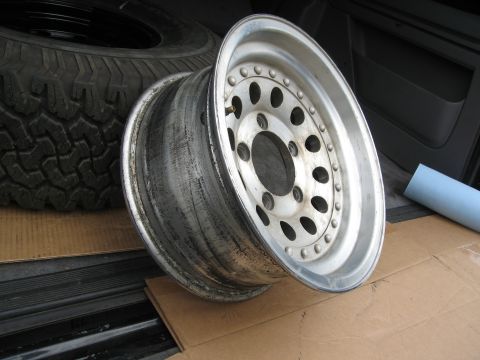 1986 Ford Bronco - A single aluminum wheel is shown with a spare tire in the background.