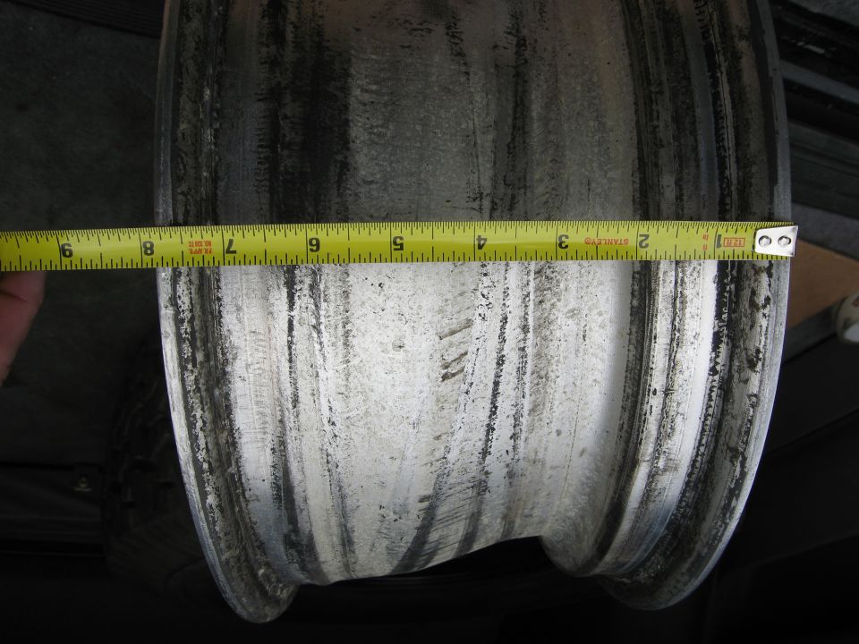Aluminum wheel rim with a yellow measuring tape showing approximately 8 inches of width
