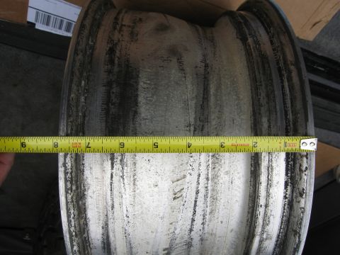 1986 Ford Bronco - A close-up shows a wheel rim with a yellow tape measure indicating its width.