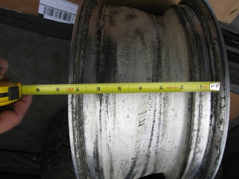1986 Ford Bronco - A tape measure is used to determine the width of a wheel rim.