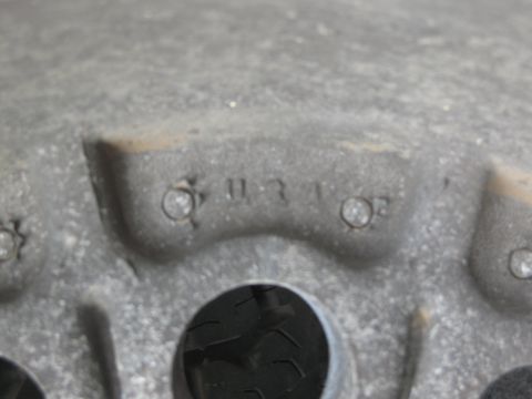 1986 Ford Bronco - A close-up view of a stamped metal part shows some numbers and circular indentations.