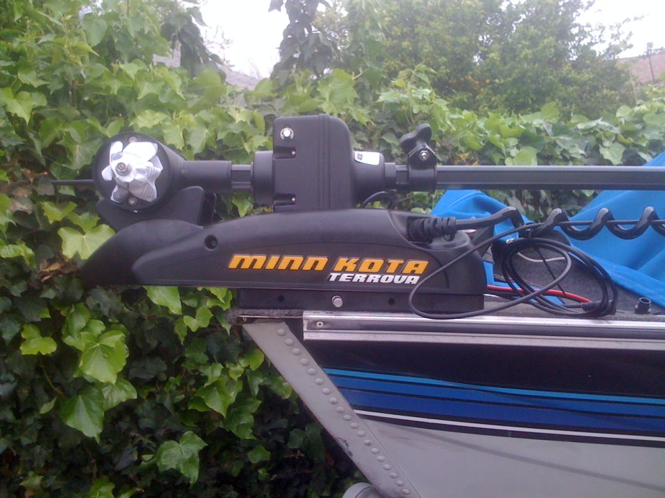 Minn Kota Terrova trolling motor mounted on a boat, with green foliage in the background