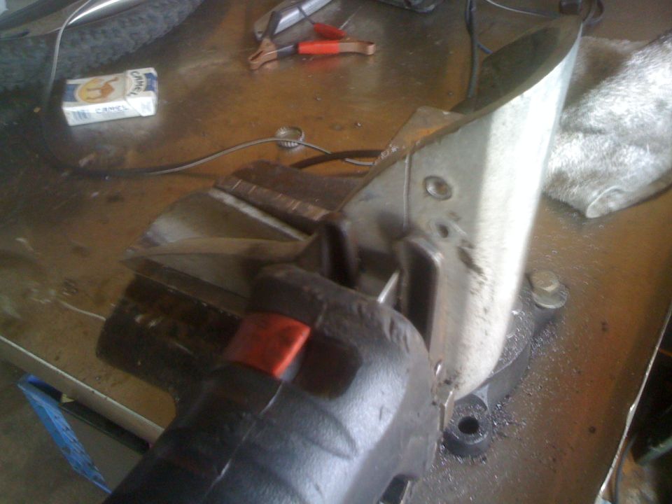 Metal part being cut in a vise with a cigarette pack nearby